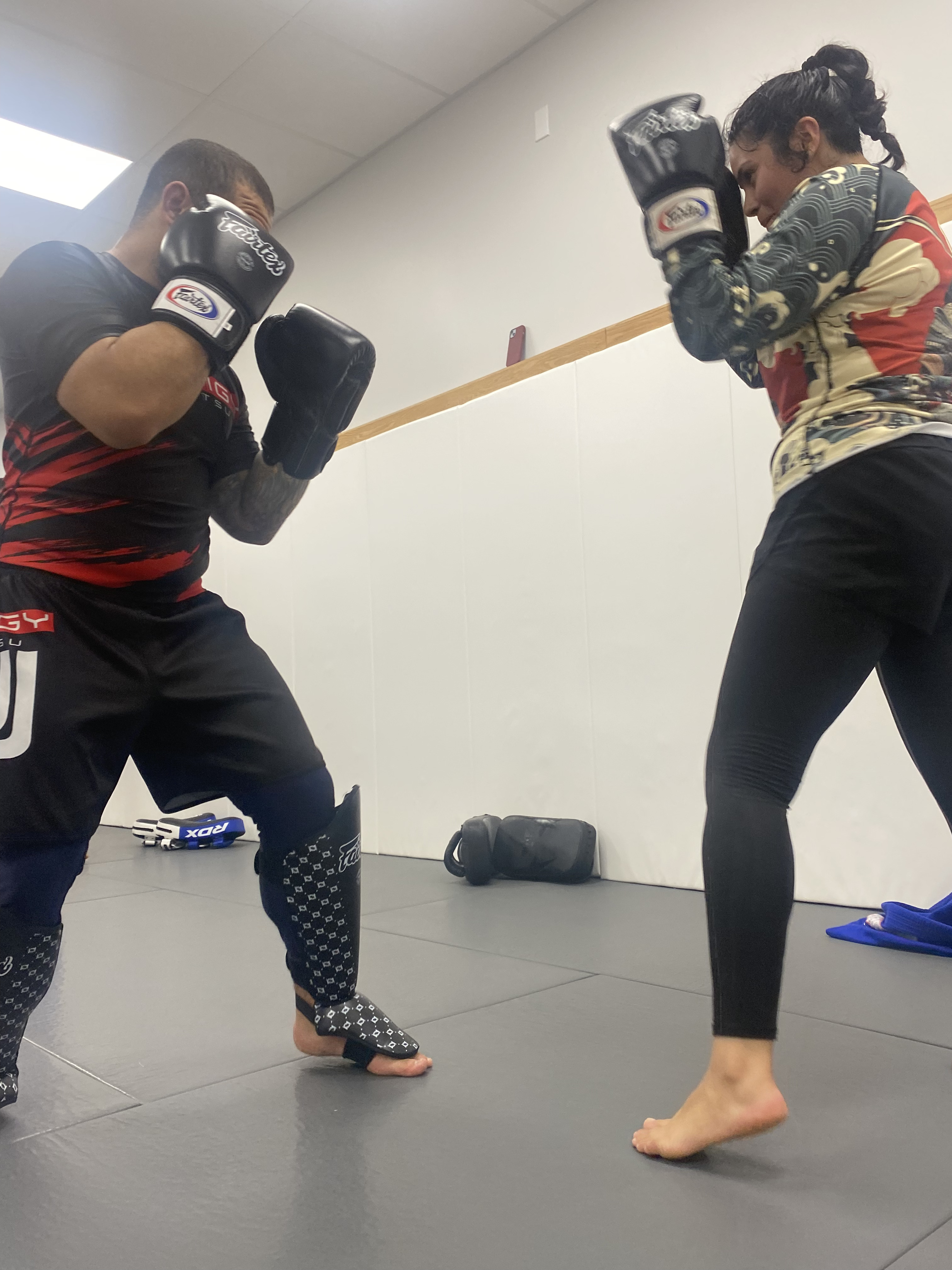 Two students sparring with boxing gloves during Muay Thai training at Prodigy Jiu-Jitsu
